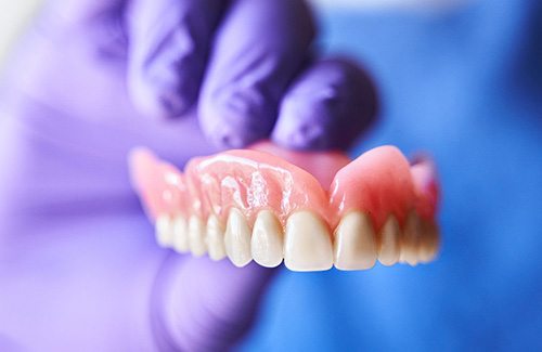 a dentist holding dentures 