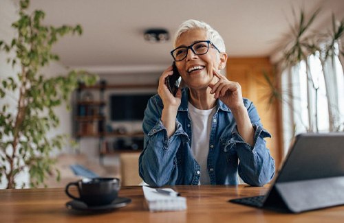 a woman smiling while talking on the phone