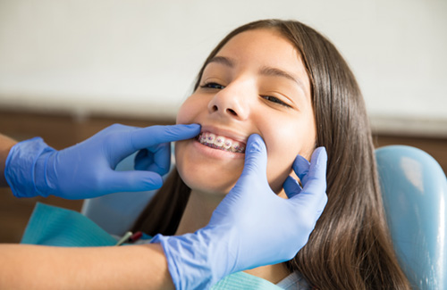 a patient with braces visiting her dentist