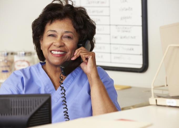 Smiling dental team member answering the phone