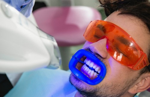 Man in dental chair getting professional teeth whitening
