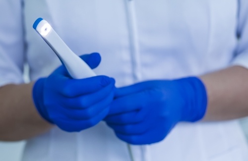 Dental team member holding a white intraoral camera device