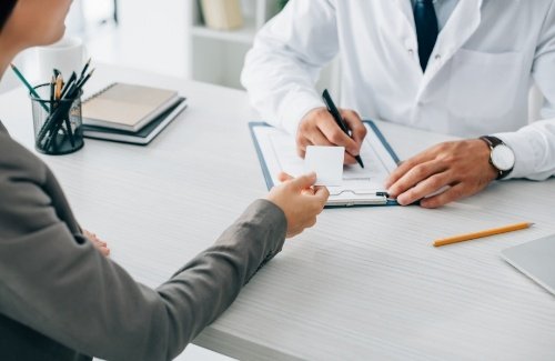 Person handing a payment card to their dentist