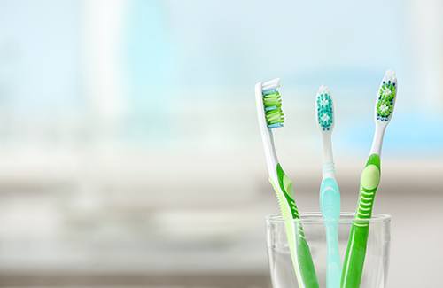 Three toothbrushes in a glass