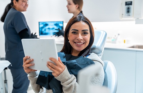 Woman smiling while holding handheld mirror