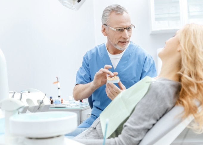 West Jordan dental team member showing a model of teeth to a patient