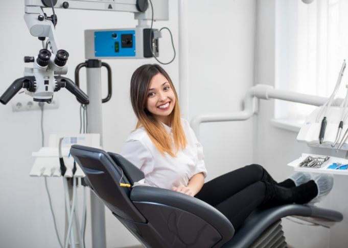 Young woman in dental chair smiling after restorative dentistry in West Jordan