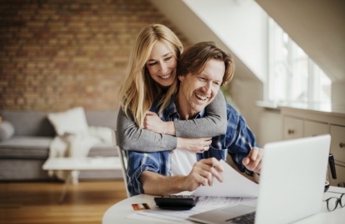 Man and woman looking at laptop for dentist reviews in West Jordan