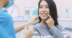 Patient smiling while dentist looks at her teeth