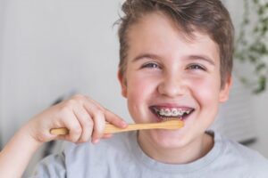 Kid brushing teeth with braces.